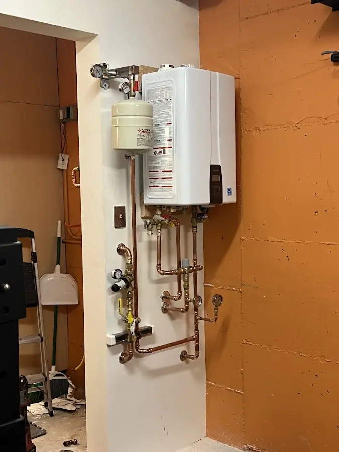 Plumbing technician inspecting water heater connections in Ridgeland